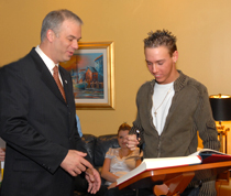 Steve Nadeau s'appr&ecirc;tant &agrave; signer le Livre d'Or de la jeunesse du SPVM, en compagnie du directeur, M. Yvan Delorme